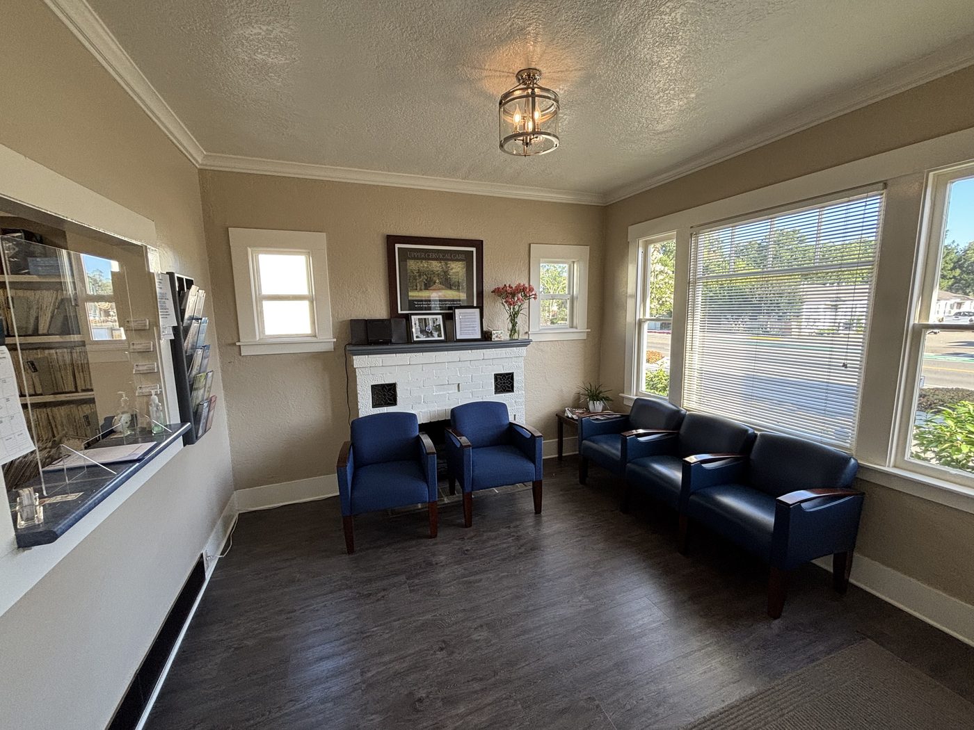 Waiting room with blue chairs and a white brick fireplace