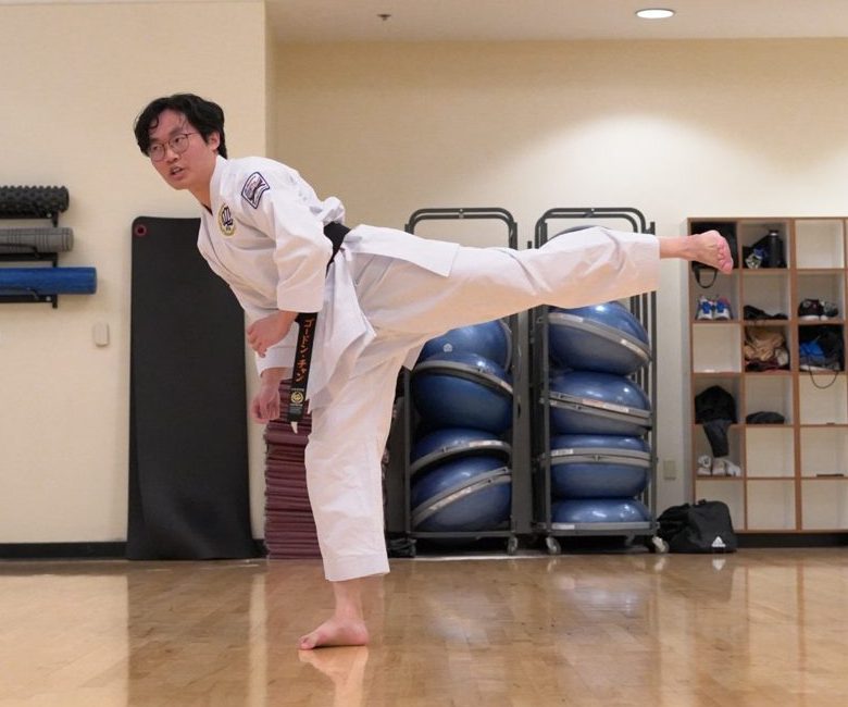 Gordon in a white gi and black belt throwing a side kick at practice