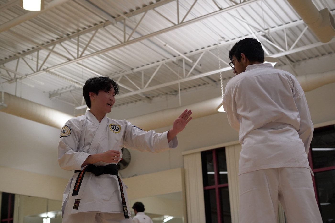 Gordon in a white gi and black belt explaining a technique to a student