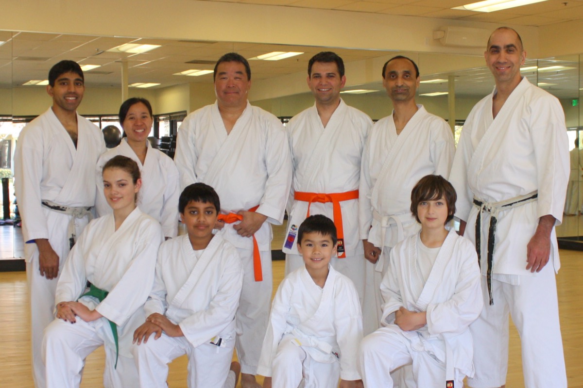 Adult and teen students with their instructors in the dojo